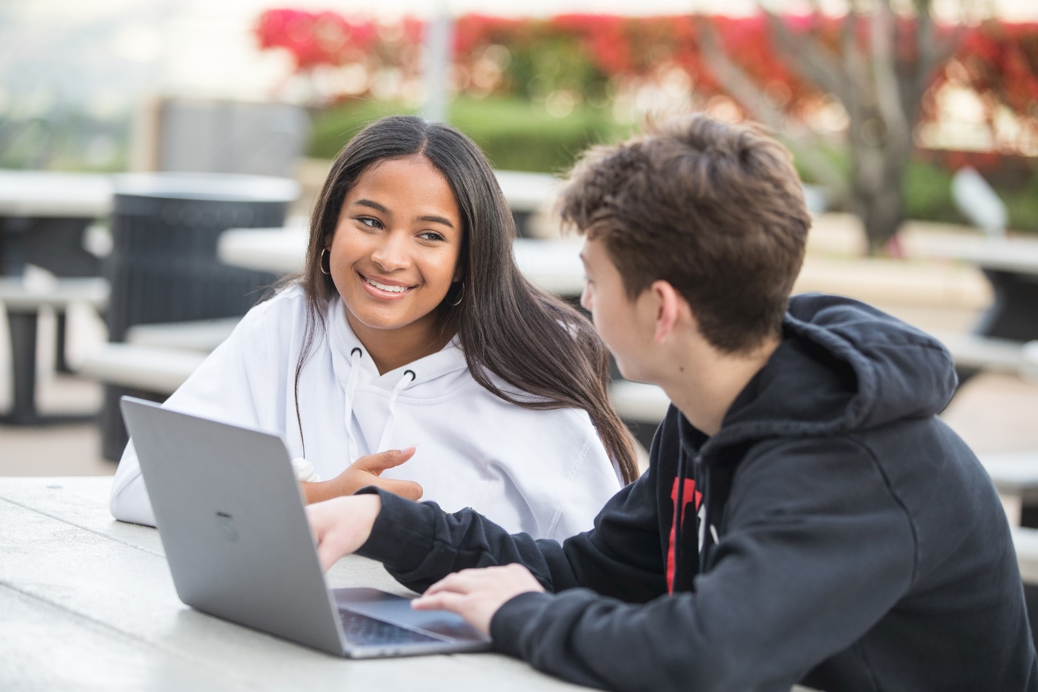 A Sierra Canyon Upper School students study outside at a picnic table on the Upper School Plaza.