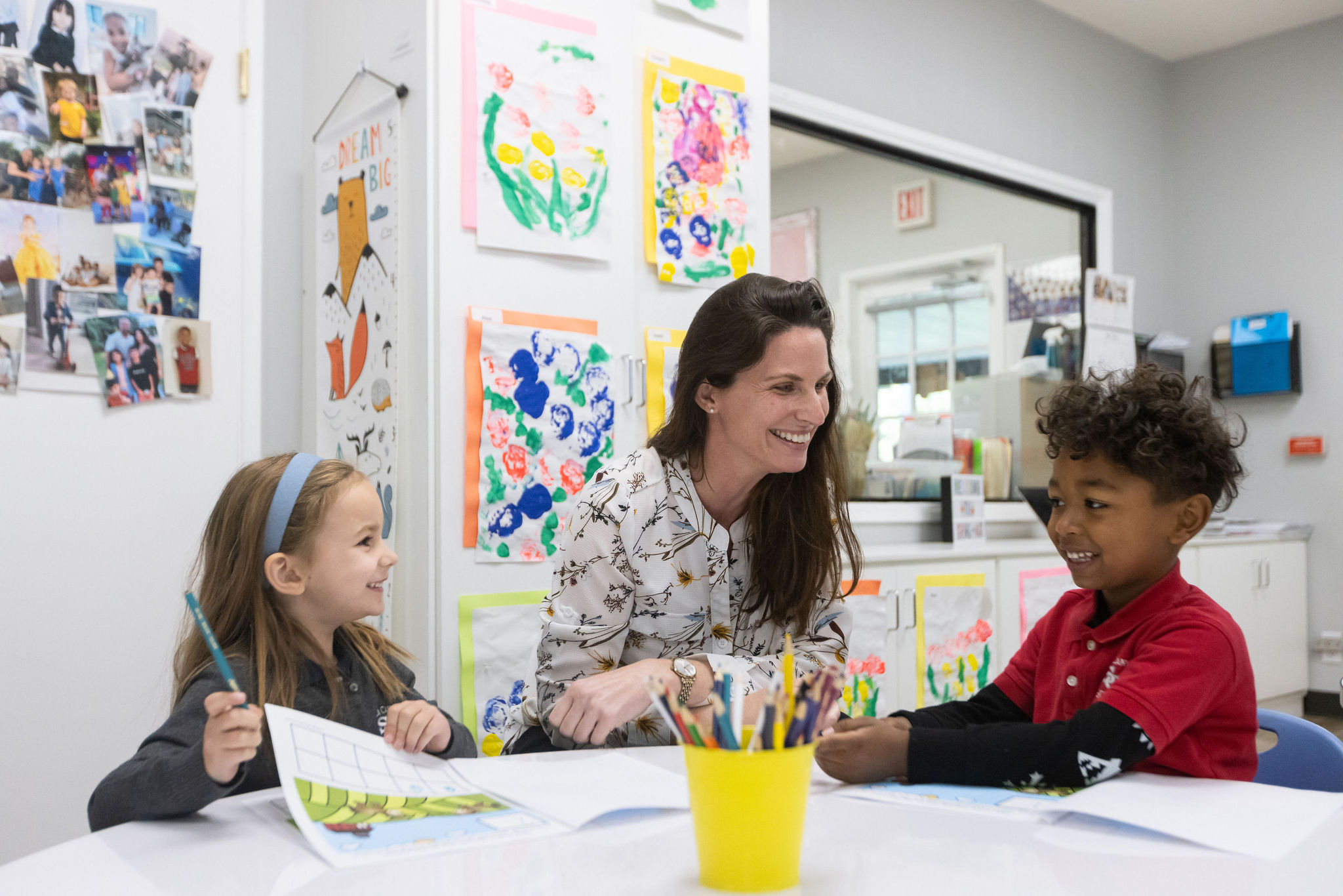 Lower school teacher and students from Sierra Canyon coloring together at a table.