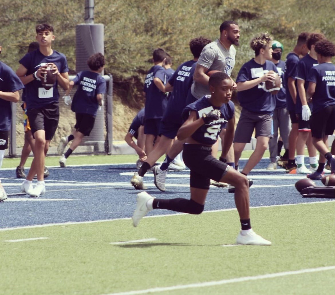 A group of young men playing football on a field.